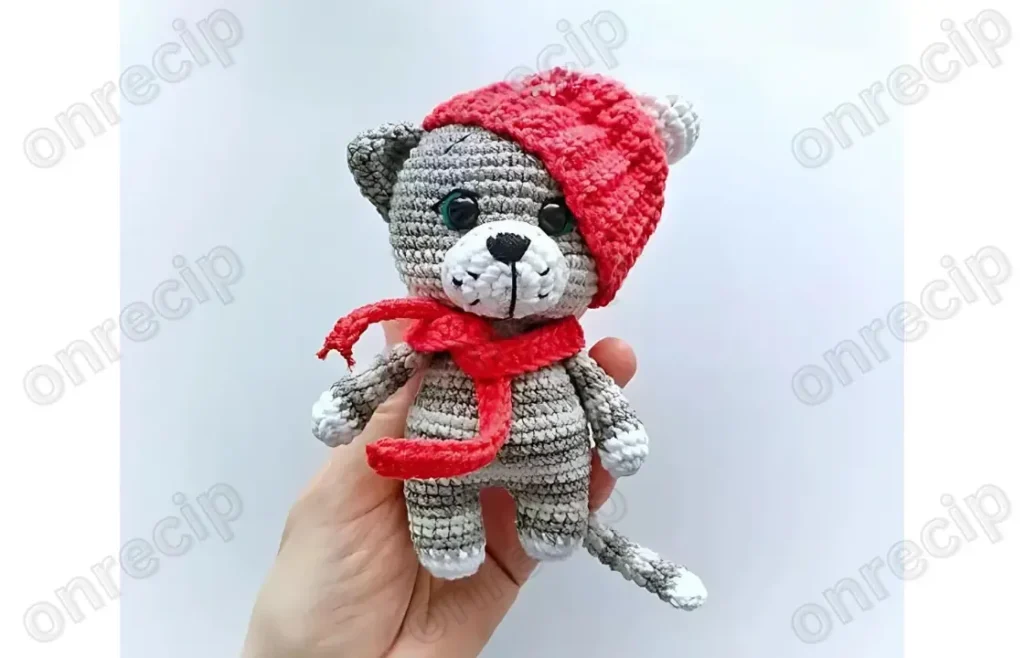 A gray and white cat amigurumi with striped arms
